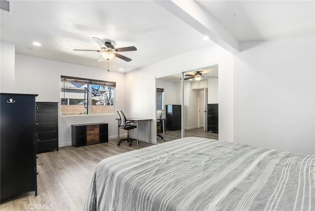 bedroom with a closet, ceiling fan, light wood-type flooring, and beam ceiling