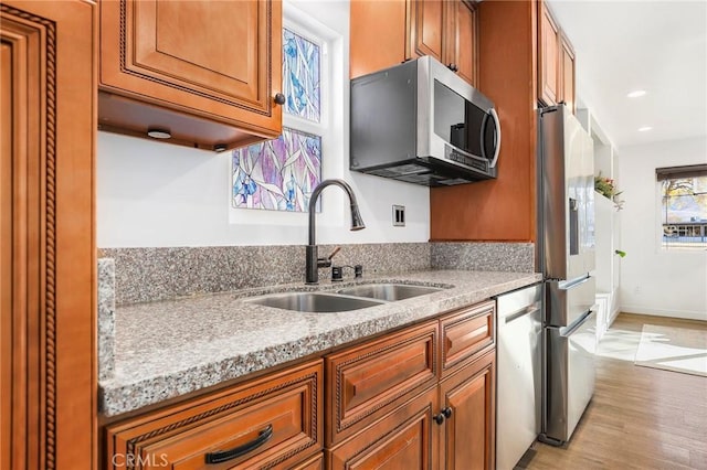 kitchen featuring stainless steel appliances, sink, and light hardwood / wood-style flooring