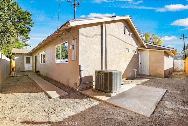 back of property featuring central air condition unit and a patio