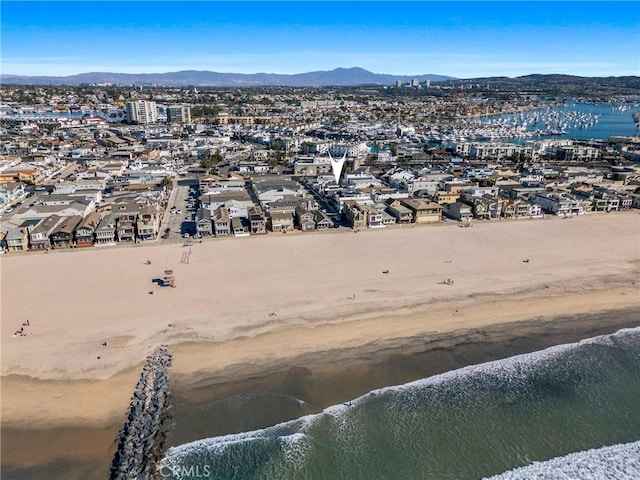 drone / aerial view featuring a water and mountain view and a view of the beach