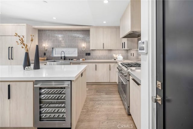 kitchen featuring range with two ovens, light hardwood / wood-style flooring, custom range hood, decorative backsplash, and wine cooler