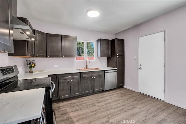 kitchen with light hardwood / wood-style floors, stainless steel appliances, wall chimney exhaust hood, sink, and dark brown cabinets