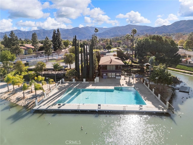 view of pool with a patio and a water and mountain view