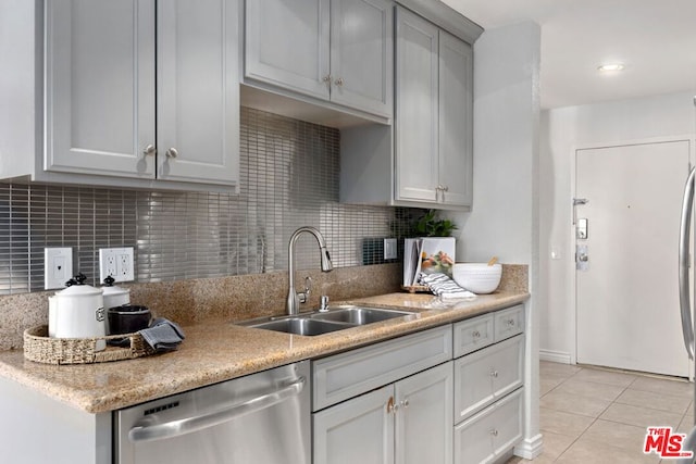 kitchen with stainless steel dishwasher, decorative backsplash, sink, and light tile patterned floors