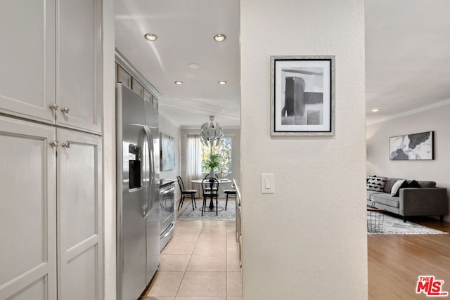 hall with light tile patterned floors and crown molding