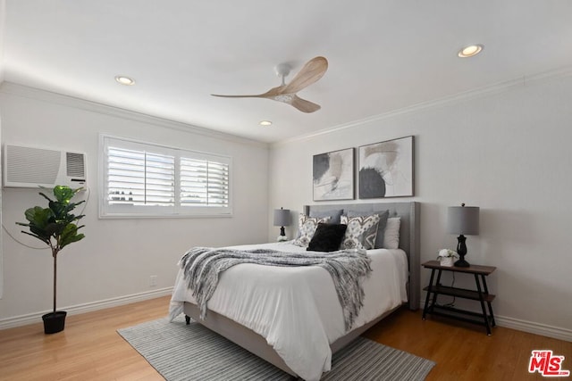 bedroom featuring wood-type flooring, an AC wall unit, ceiling fan, and crown molding