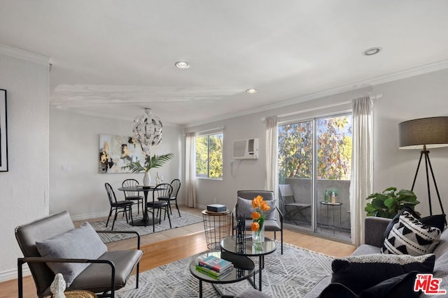 living room featuring light hardwood / wood-style floors, a notable chandelier, a wall mounted air conditioner, and crown molding