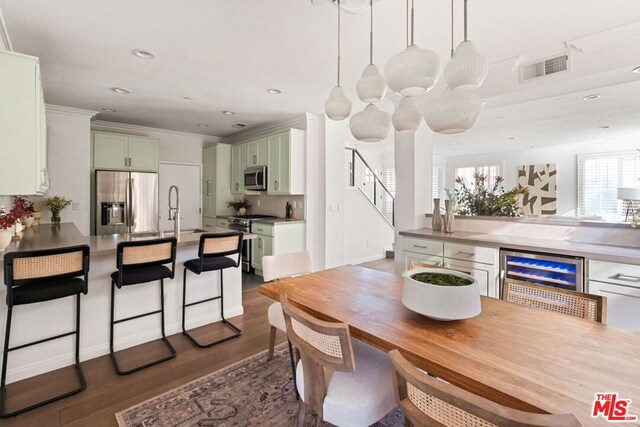 dining area with sink, dark wood-type flooring, and wine cooler