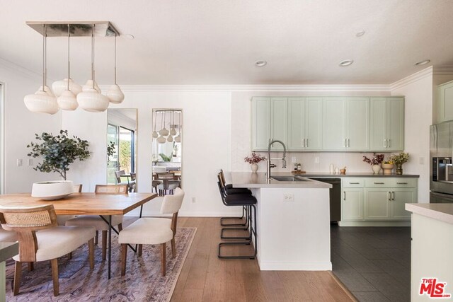 kitchen with pendant lighting, green cabinetry, dishwasher, and stainless steel fridge with ice dispenser