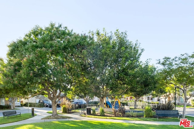 view of home's community with a playground and a lawn