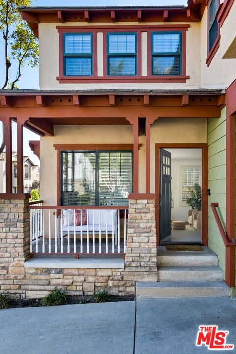 view of exterior entry featuring covered porch