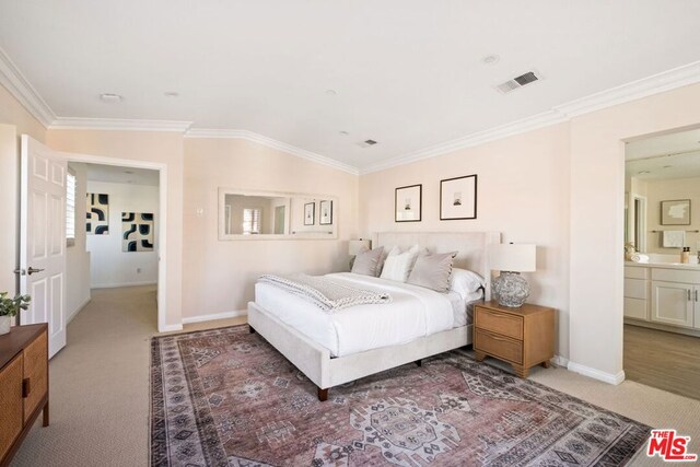 carpeted bedroom featuring ensuite bath, vaulted ceiling, and ornamental molding