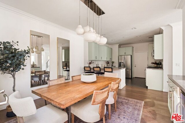 dining area featuring crown molding, dark hardwood / wood-style flooring, and sink