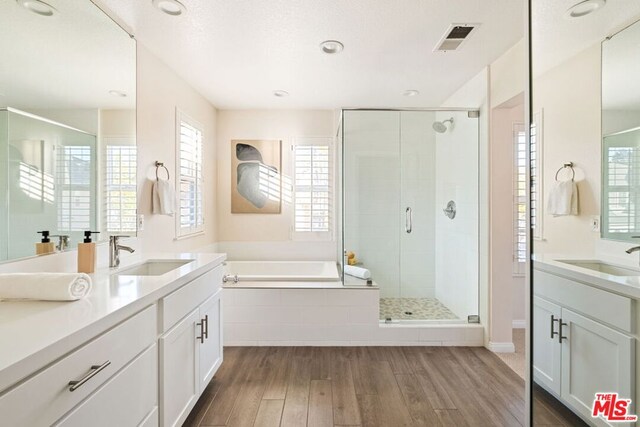 bathroom featuring shower with separate bathtub, vanity, and hardwood / wood-style floors