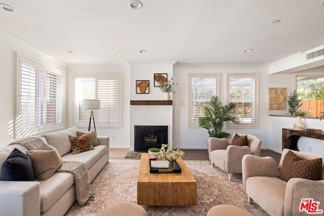 living room featuring plenty of natural light, light hardwood / wood-style flooring, and crown molding