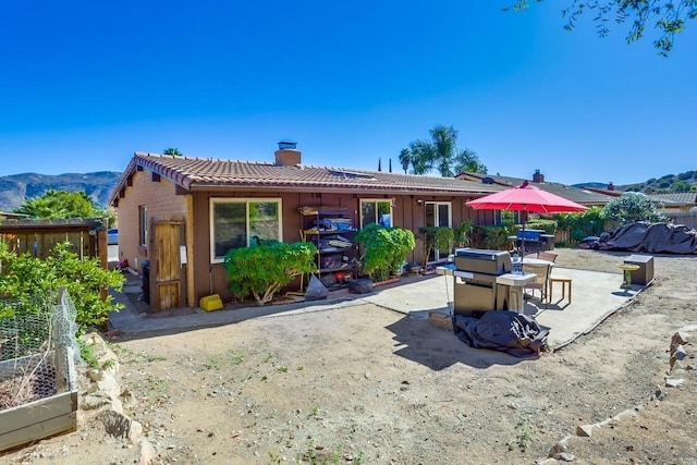 rear view of property with a patio and a mountain view