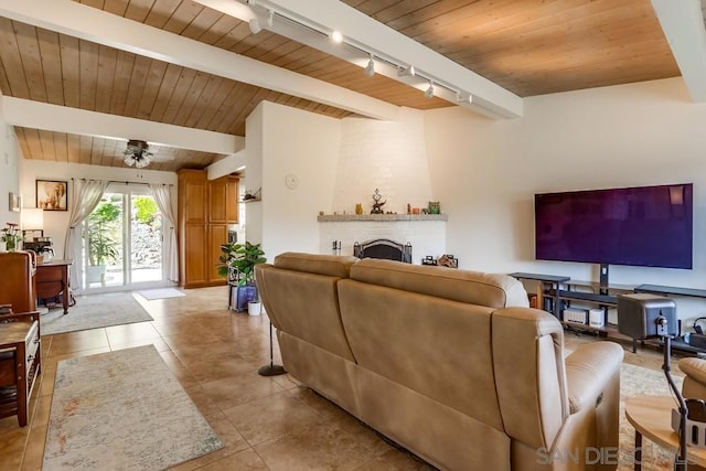 tiled living room with a brick fireplace, track lighting, ceiling fan, and wood ceiling