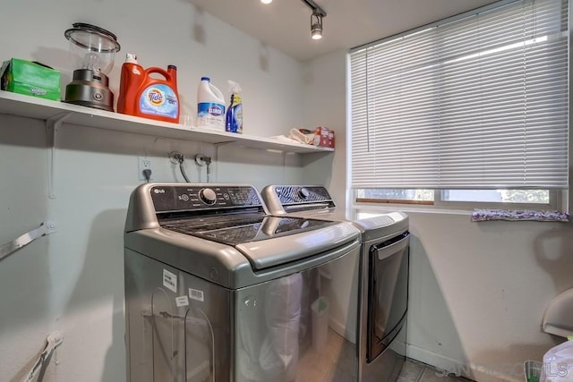 washroom with rail lighting and separate washer and dryer