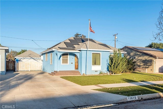 bungalow with a front yard and solar panels