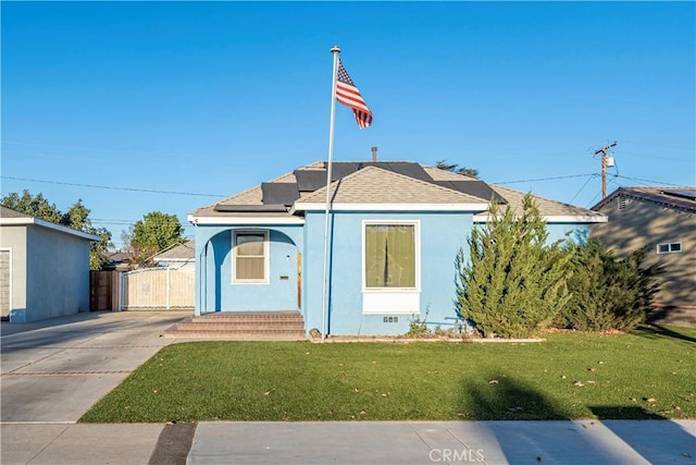 bungalow-style home featuring a front yard and solar panels