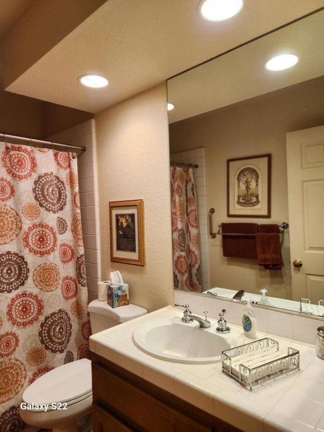 bathroom featuring vanity, walk in shower, and toilet