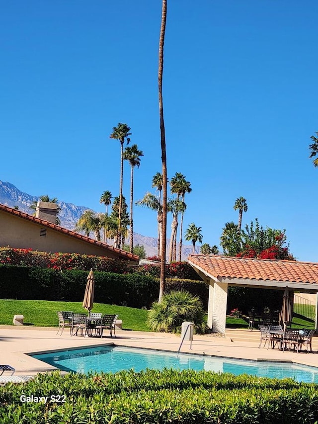 view of pool with a mountain view, a patio area, and a pergola