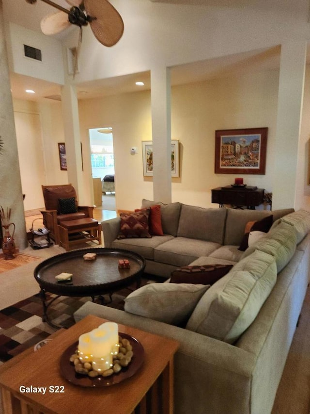 living room featuring ceiling fan and a high ceiling