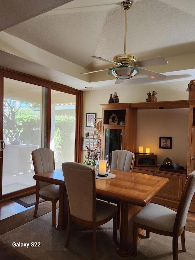 dining room with a textured ceiling, vaulted ceiling, and ceiling fan