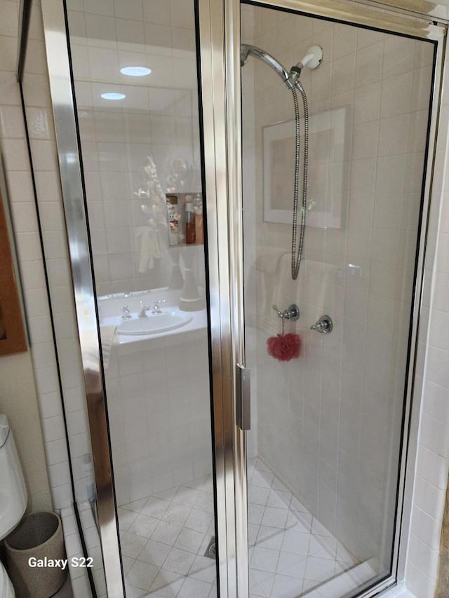 bathroom featuring sink and a shower with shower door