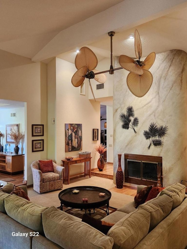 living room with lofted ceiling, a fireplace, and ceiling fan