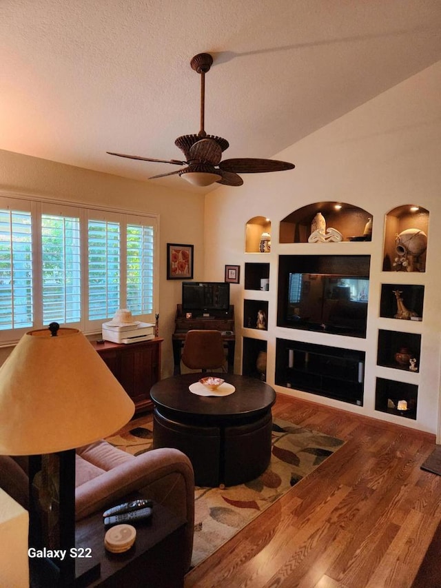 living room with a textured ceiling, hardwood / wood-style floors, built in features, and ceiling fan