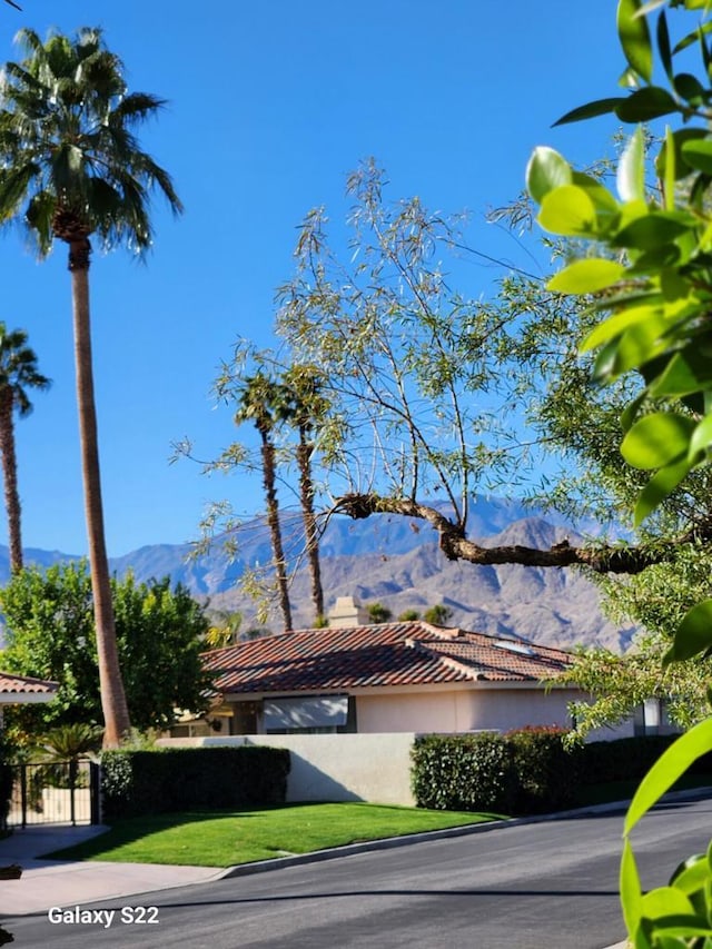 view of side of home with a mountain view and a yard