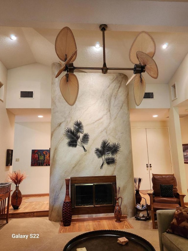 living room with a large fireplace and high vaulted ceiling