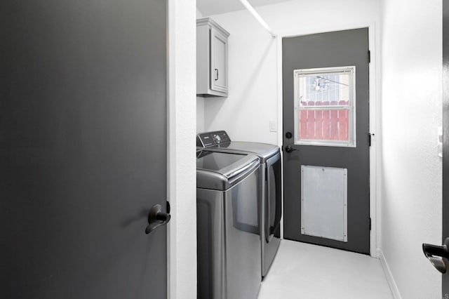 clothes washing area featuring washer and clothes dryer and cabinets