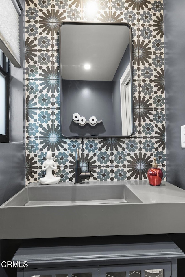 bathroom with sink and decorative backsplash