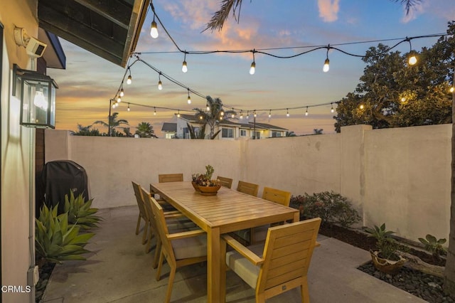 patio terrace at dusk featuring a grill