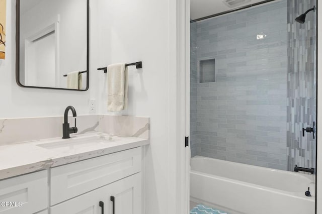 bathroom with tiled shower / bath and vanity