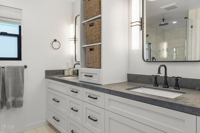 bathroom with a shower with door and vanity