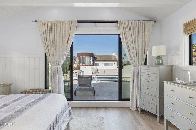 bedroom featuring lofted ceiling with beams and light hardwood / wood-style flooring