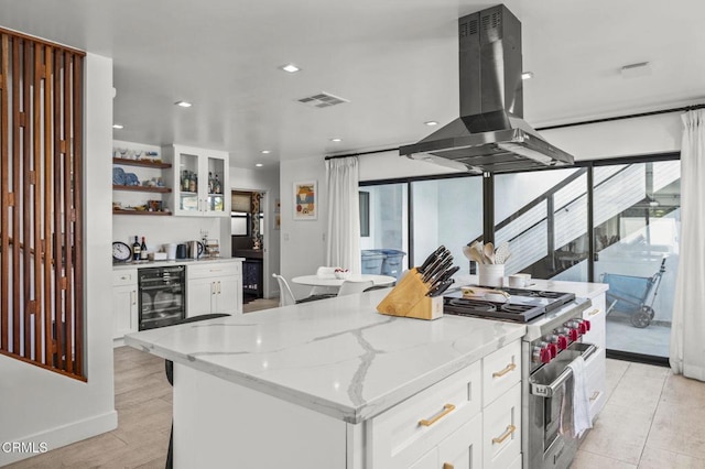 kitchen featuring white cabinetry, stainless steel range, and island exhaust hood