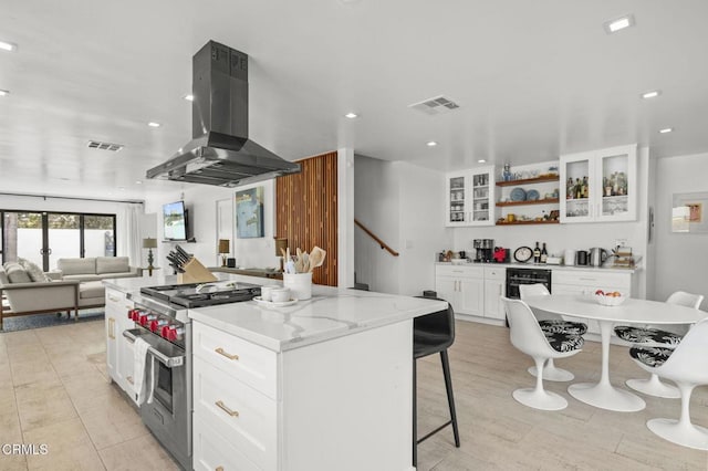 kitchen with white cabinetry, a center island, stainless steel range, island exhaust hood, and light stone countertops