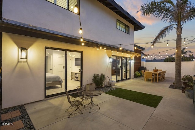 back house at dusk featuring a patio