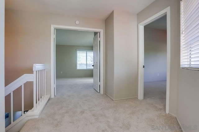 corridor featuring light colored carpet