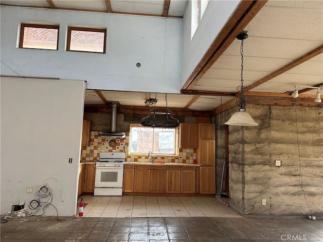 kitchen with sink, white gas range, track lighting, backsplash, and hanging light fixtures