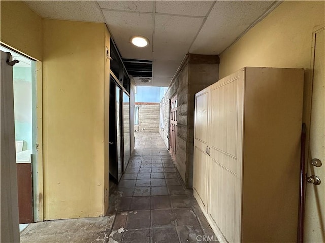 hall featuring a paneled ceiling