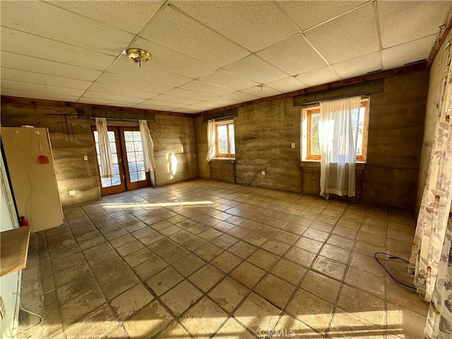 empty room featuring french doors and a paneled ceiling