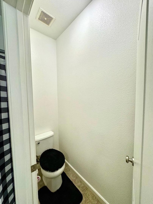 bathroom featuring toilet and tile patterned floors