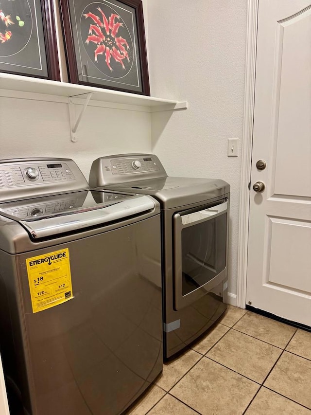 clothes washing area featuring light tile patterned flooring and independent washer and dryer