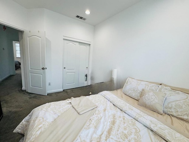 bedroom featuring dark colored carpet and a closet