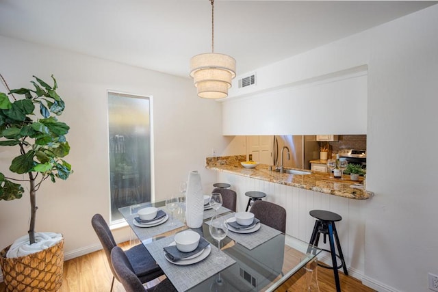 dining space featuring sink and light hardwood / wood-style floors